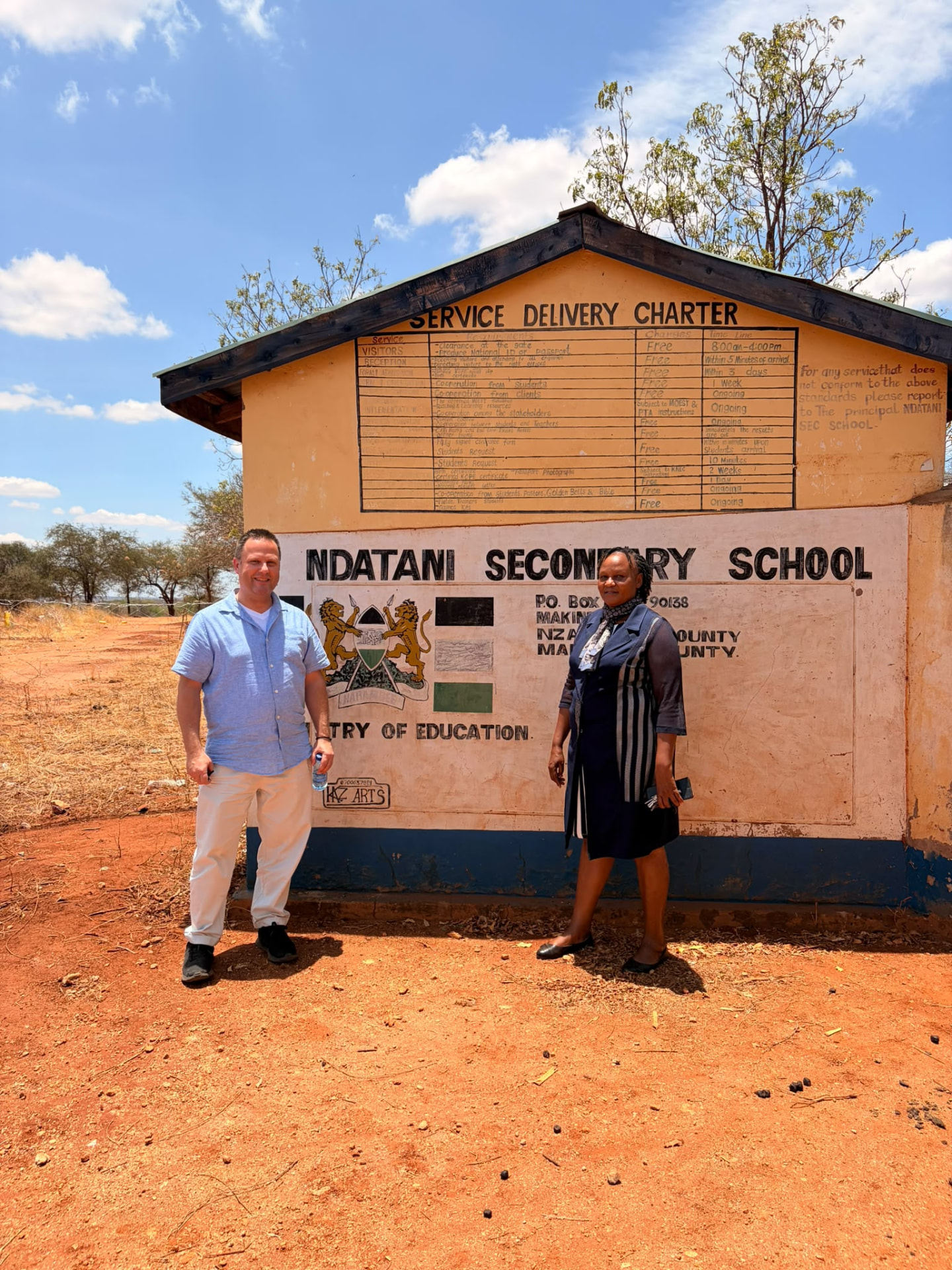 Visitors in front of the Ndatani Secondary School sign